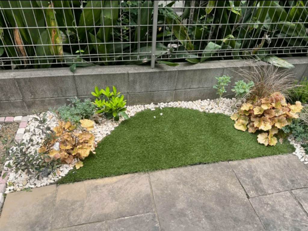 曲線にカットされ柔らかい印象の人工芝と砂利、植栽のコラボレーション