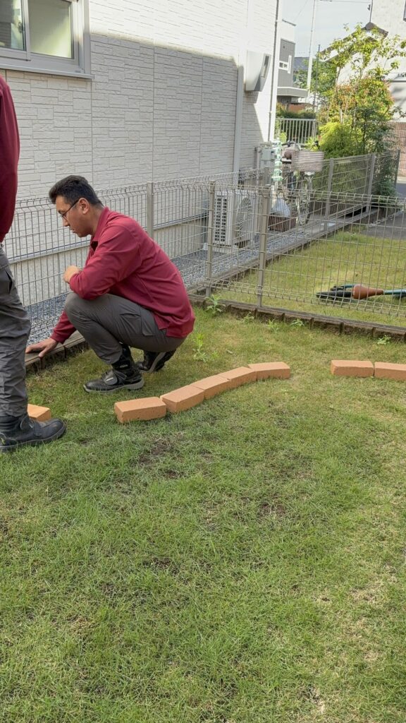 外構工事の職人が、現場の状況を確認し、花壇やフェンスを施工します。